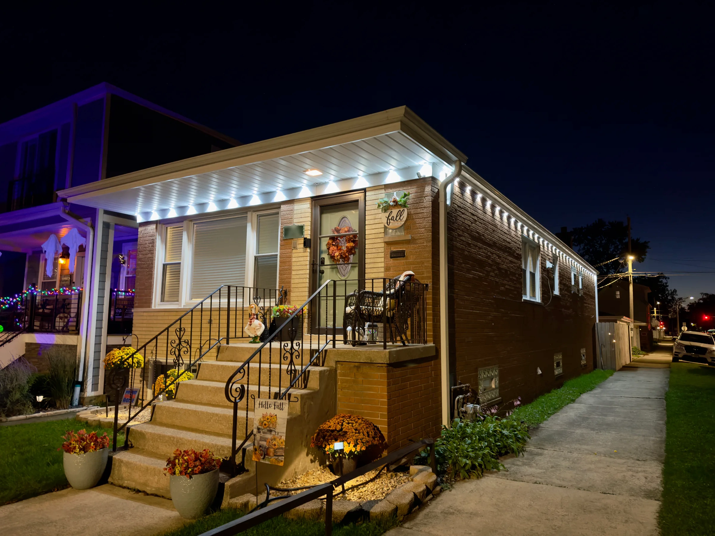 Northline-installed white lights along the front and side of a brick home
